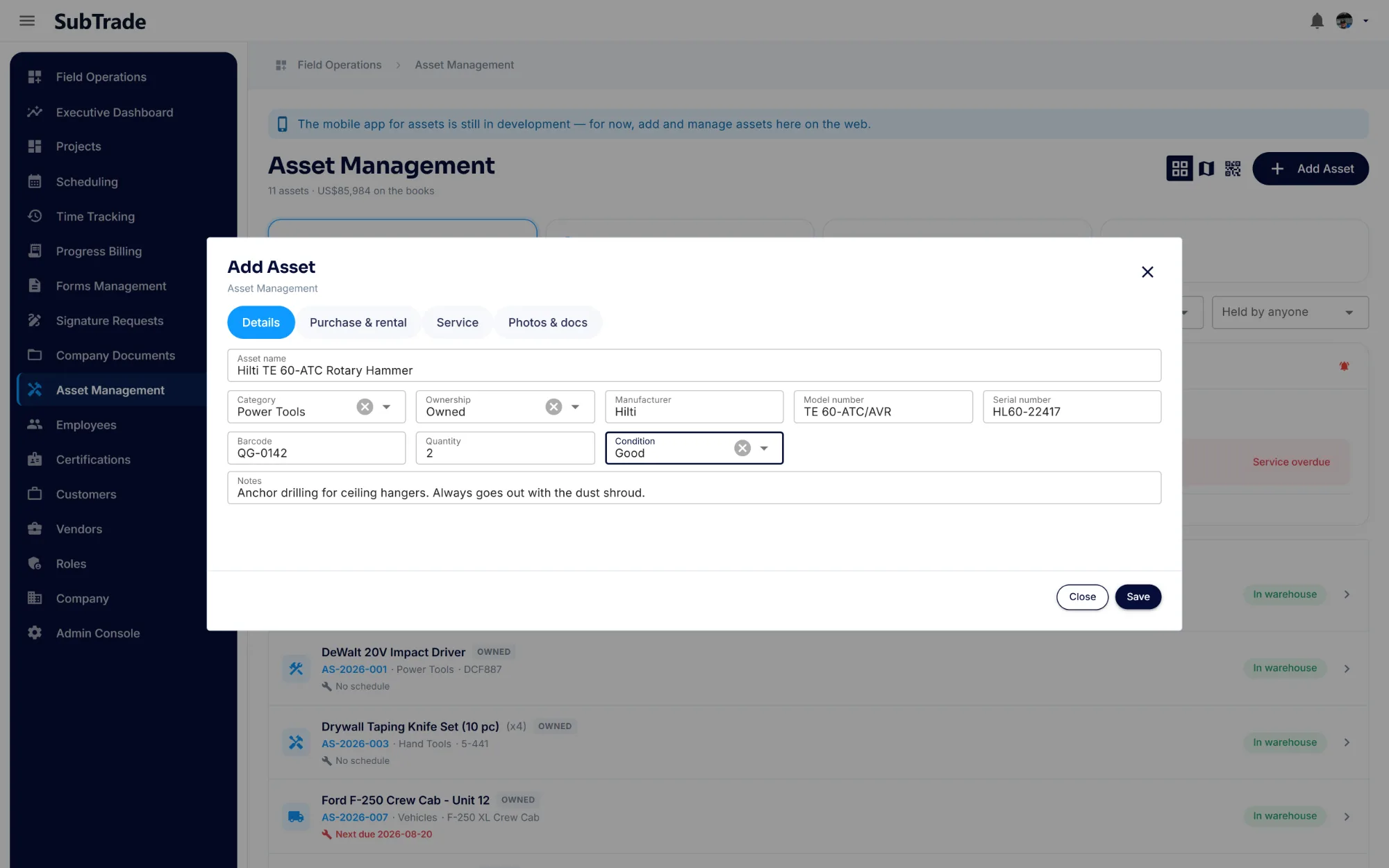 The Add Asset dialog in SubTrade on its Details tab, with asset name, category, ownership, manufacturer, model number, serial number, barcode, quantity, condition and notes filled in for a rotary hammer
